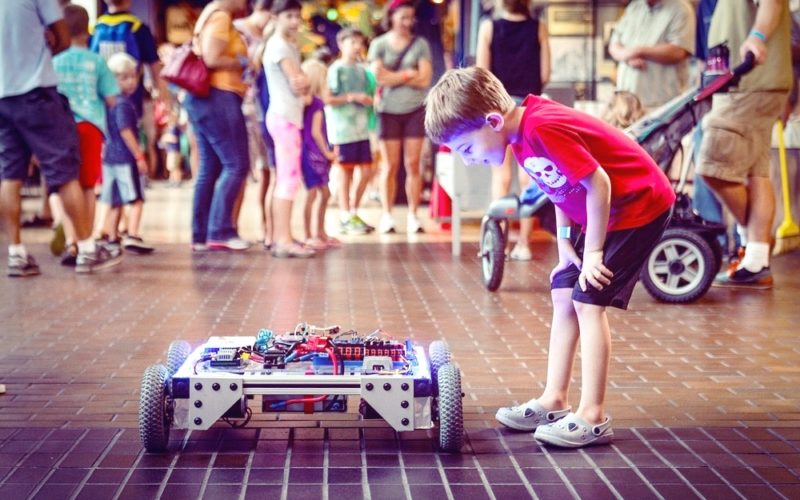 A boy is looking at a maker faire project during Makerfair festival